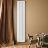 Traditionele witte 4-kolom radiator van 1800 x 380 mm met haakse thermostaatkraan, geplaatst tegen een warme, neutrale muur