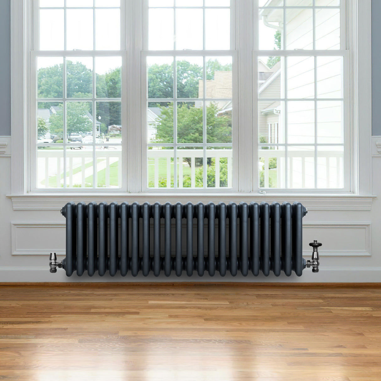 Traditionele 4-kolom radiator in antraciet grijs, met een gladde afwerking en een robuuste, retro uitstraling, geplaatst onder een raam