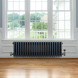 Traditionele 4-kolom radiator in antraciet grijs, met een gladde afwerking en een robuuste, retro uitstraling, geplaatst onder een raam