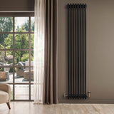 Traditionele zwarte 4-kolom radiator van 1800 x 380 mm, met een glanzende afwerking en stijlvolle messing aansluitingen, tegen een neutrale muur