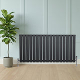 Design radiator met vlakke panelen in antraciet grijs, 1 kolom, 600 x 1190mm, geplaatst naast een groene plant in een moderne ruimte