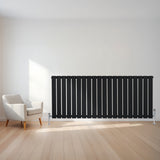 Zwarte design radiator met vlakke panelen, 1 kolom, 600 x 1400mm, geplaatst tegen een lichte muur in een moderne ruimte met houten vloer