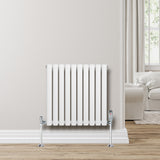 Ovale design radiator in wit met één kolom, 600 mm x 600 mm, geplaatst tegen een lichte muur in een moderne woonkamer