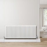 Ovale design radiator in wit met één kolom, 600 mm x 1440 mm, geplaatst tegen een lichte muur in een moderne woonkamer met houten vloer
