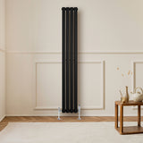 Ovale zwarte designradiator met één kolom, 1600 mm x 240 mm, geplaatst tegen een lichte muur in een moderne woonkamer