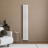 Ovale witte designradiator van 1600 mm x 240 mm met een moderne uitstraling, geplaatst tegen een beige muur in een stijlvolle woonkamer