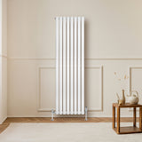Ovale witte design radiator met één kolom, 1600 mm x 480 mm, geplaatst tegen een lichte muur in een moderne interieursetting