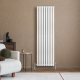 Ovale design radiator in wit met één kolom, 1600 mm x 480 mm, geplaatst tegen een warme, neutrale muur in een moderne woonkamer