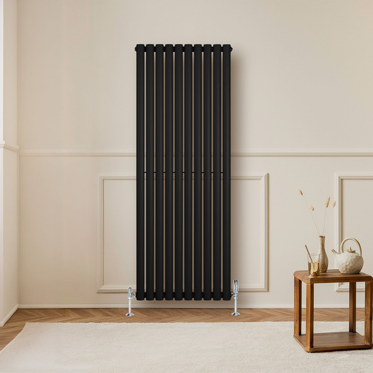 Ovale zwarte design radiator van 1600 mm x 600 mm met een moderne, strakke uitstraling en verticale kolommen in een lichte kamer