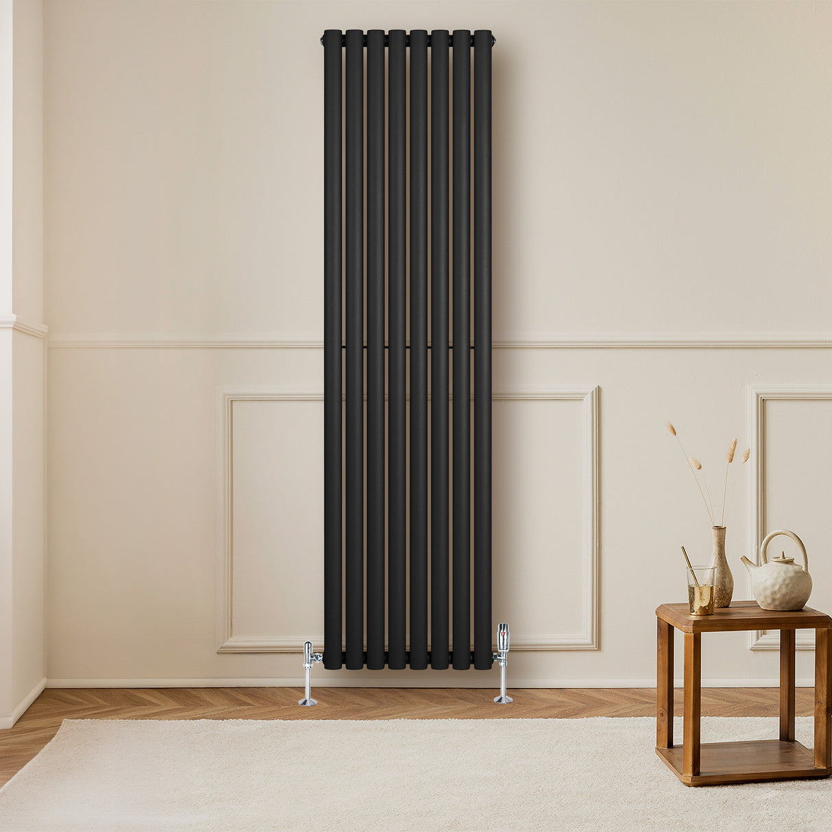 Ovale zwarte designradiator van 1800 mm x 480 mm met een moderne, strakke uitstraling en verticale kolommen in een lichte kamer