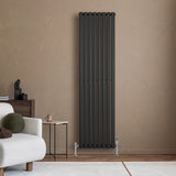 Ovale zwarte designradiator van 1800 mm x 480 mm met een moderne, strakke uitstraling, geplaatst tegen een neutrale muur