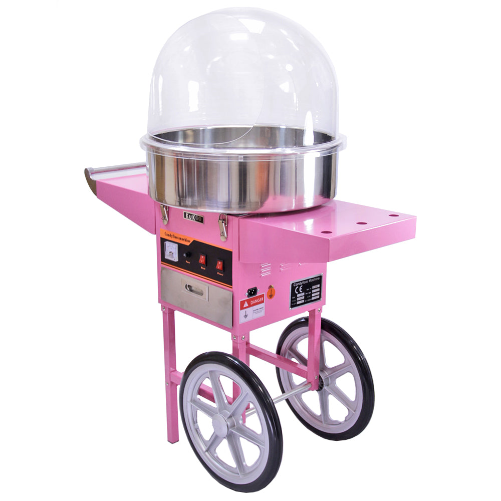 Roze suikerspinmachine met een glanzende metalen kom en een transparante beschermkap, geplaatst op een stevige wagen met wielen