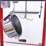 Glanzende metalen pan hangt aan een robuuste, rode popcornmachine met een handvat en verstelbare haakjes voor gebruiksgemak