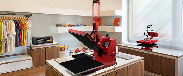 Rode hittepers op een houten tafel in een moderne ruimte, omringd door kleding en drukapparatuur, met een lichte achtergrond